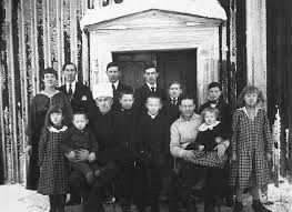 Carl-Magnus Hedman och Greta född Karlsdotter med sina 12 gemensamma barn ca år 1917 framför gamla bostadshuset.